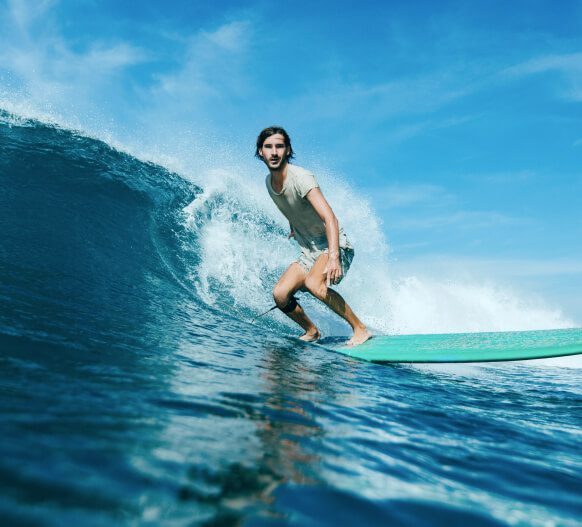 Surfer On A Wave With Blue Ocean & Sky Img